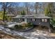 Beautiful home with a slate gray exterior, a turquoise door, covered carport, and mature trees at 3240 Pinestream Nw Rd, Atlanta, GA 30327