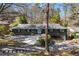 Ranch-style house with charcoal exterior, light blue front door, and driveway leading to a carport at 3240 Pinestream Nw Rd, Atlanta, GA 30327