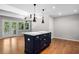 Kitchen boasts a large dark blue island with marble countertop and modern pendant lighting at 3240 Pinestream Nw Rd, Atlanta, GA 30327