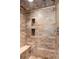 Walk-in shower tiled with beautiful decorative stone and a built-in bench at 3240 Pinestream Nw Rd, Atlanta, GA 30327