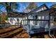 Rear exterior view of the home showcasing a deck, sliding glass door, and windows at 40 Cumberland Dr, Rex, GA 30273