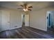 Spacious bedroom with hardwood floors, neutral walls, and ceiling fan with views to the bathroom at 40 Cumberland Dr, Rex, GA 30273