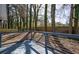 Wooden deck with painted railings overlooks backyard lined with mature trees and a wooden fence at 40 Cumberland Dr, Rex, GA 30273