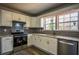 Close-up of a kitchen featuring stainless steel appliances, subway tile backsplash, and white cabinets at 40 Cumberland Dr, Rex, GA 30273