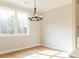 Sun-filled dining area with large windows, wood floors, and a modern chandelier at 4818 Floydwood Ln, Mableton, GA 30126