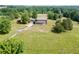 Aerial view showcasing a home with a large yard, mature trees and driveway to a detached garage at 4840 Pisgah Rd, Cumming, GA 30028