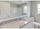 Bathroom featuring granite counters, white cabinetry, large mirror, and tub with shower at 4840 Pisgah Rd, Cumming, GA 30028