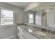 This bathroom features a double sink vanity with granite counters and natural light at 4840 Pisgah Rd, Cumming, GA 30028