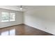 Bedroom featuring hardwood floors, ceiling fan, and a bright window for natural light at 4840 Pisgah Rd, Cumming, GA 30028