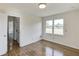 Bedroom featuring hardwood floors and a bright window with a door leading to the hallway at 4840 Pisgah Rd, Cumming, GA 30028