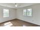 Bedroom featuring hardwood floors, ceiling fan, and bright windows for ample natural light at 4840 Pisgah Rd, Cumming, GA 30028