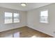 Sunlit bedroom with hardwood floors and large windows offering pleasant outdoor views at 4840 Pisgah Rd, Cumming, GA 30028