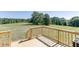 Sunny wooden deck with railing overlooking a vast green lawn and trees at 4840 Pisgah Rd, Cumming, GA 30028