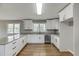 Modern kitchen boasts granite counters, stainless appliances, and ample white cabinetry at 4840 Pisgah Rd, Cumming, GA 30028