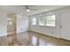 Bright living room with hardwood floors, a ceiling fan, and a white door at 4840 Pisgah Rd, Cumming, GA 30028