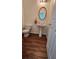 Powder room featuring a pedestal sink, oval mirror, and hardwood floors at 553 Rockbridge Trl, Stone Mountain, GA 30083
