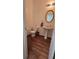 Powder room featuring a pedestal sink, oval mirror, and hardwood floors at 553 Rockbridge Trl, Stone Mountain, GA 30083