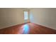 This bedroom has wood floors, neutral walls, and a window for natural lighting at 553 Rockbridge Trl, Stone Mountain, GA 30083
