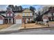 Two-story townhome featuring a brick and yellow exterior, attached garage, and manicured lawn at 553 Rockbridge Trl, Stone Mountain, GA 30083