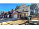 Two-story townhome featuring a brick and yellow exterior, attached garage, and well-kept lawn at 553 Rockbridge Trl, Stone Mountain, GA 30083