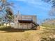 Back exterior of home featuring a wooden deck with stairs leading to a spacious backyard at 1110 Robert Pointe Way, Lawrenceville, GA 30045