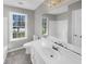 Well-lit bathroom featuring a large mirror, single sink vanity and ample natural light at 1110 Robert Pointe Way, Lawrenceville, GA 30045