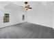 This bright main bedroom features tray ceilings, a ceiling fan and plush gray carpeting at 1110 Robert Pointe Way, Lawrenceville, GA 30045