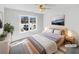 Bright bedroom featuring a large window, a bed with gray bedding, and stylish decor at 1110 Robert Pointe Way, Lawrenceville, GA 30045