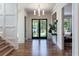 Bright foyer featuring hardwood floors, large front door with sidelights, chandelier, and a view into other rooms at 1442 Cedarhurst Dr, Dunwoody, GA 30338
