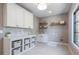 Clean laundry room with white cabinets, folding counter, and convenient storage baskets at 1442 Cedarhurst Dr, Dunwoody, GA 30338