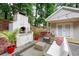 Inviting backyard patio with a wood-burning oven, comfortable seating, and ambient string lights for outdoor enjoyment at 1584 Carroll Nw Dr, Atlanta, GA 30318