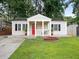 Charming single-story home featuring a classic design, a welcoming red door, and a well-manicured lawn at 1584 Carroll Nw Dr, Atlanta, GA 30318
