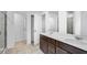 A well-lit bathroom with double vanity, quartz countertop, and tiled shower at 205 Groveton Ct, Euharlee, GA 30145