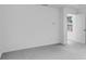 A modern bedroom featuring gray carpet and a doorway with natural light shining through at 205 Groveton Ct, Euharlee, GA 30145