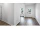 Hallway with wood flooring, featuring access to another room and a bright white front door at 205 Groveton Ct, Euharlee, GA 30145