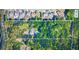 Aerial view shows a home in a wooded area with a pool in the backyard, surrounded by other houses at 2410 Glade Overlook, Cumming, GA 30041