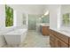 Bright bathroom with double vanities, marble floors, a large soaking tub, and glass walk-in shower at 2410 Glade Overlook, Cumming, GA 30041