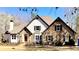 Two-story home featuring stone and siding with a manicured lawn and inviting entrance at 2410 Glade Overlook, Cumming, GA 30041