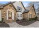 Detailed front exterior showcasing stone accents, a wooden door, stone steps and landscaped garden beds at 2410 Glade Overlook, Cumming, GA 30041