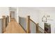 Hallway with hardwood floors, iron and wood banisters, and a view to the front door with a transom window at 2410 Glade Overlook, Cumming, GA 30041