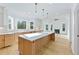 Spacious kitchen features a long island, light wood cabinets, stainless steel appliances and an open concept to the living room at 2410 Glade Overlook, Cumming, GA 30041