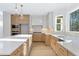 Bright kitchen featuring a long center island, light wood cabinets, and stainless steel appliances at 2410 Glade Overlook, Cumming, GA 30041