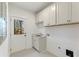 Bright laundry room with white cabinets, a utility sink, and a door leading to the backyard at 2410 Glade Overlook, Cumming, GA 30041