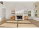 Spacious living room featuring hardwood floors, a fireplace, built-in shelving and lots of natural light at 2410 Glade Overlook, Cumming, GA 30041