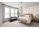 Bright bedroom featuring a cozy bed, patterned accent wall, and large windows with neighborhood views at 2453 Red Maple Se Xing # 118, Smyrna, GA 30080