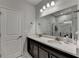 A view of the bathroom with a double vanity, modern fixtures, and large mirror reflecting the glass enclosed shower at 811 Pineberry Ct, Grayson, GA 30017