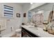 Bright bathroom featuring white countertop, framed pictures on the wall, and framed window at 811 Pineberry Ct, Grayson, GA 30017