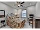 Cozy bedroom featuring a decorative bed frame, ceiling fan, and a large window with neighborhood views at 811 Pineberry Ct, Grayson, GA 30017