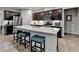 Modern open-concept kitchen featuring a large island with seating, dark cabinets, and stainless appliances at 811 Pineberry Ct, Grayson, GA 30017