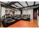 Large basement with dark brown leather sectional, drop lighting, and black wood trim at 989 Queen Elizabeth Way, Morrow, GA 30260